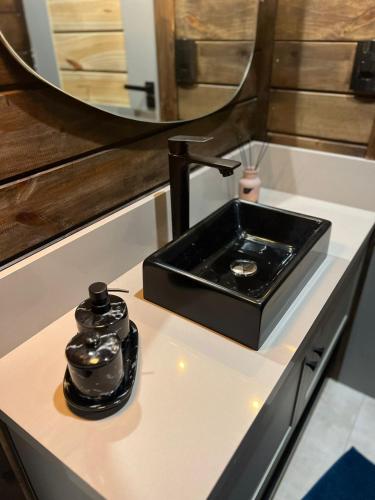 a bathroom counter with a sink and a mirror at Cabana Trinca Ferro in São Pedro de Alcântara