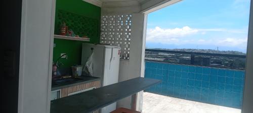 a kitchen with a refrigerator and a view of the city at Suite Grande Rio in Duque de Caxias