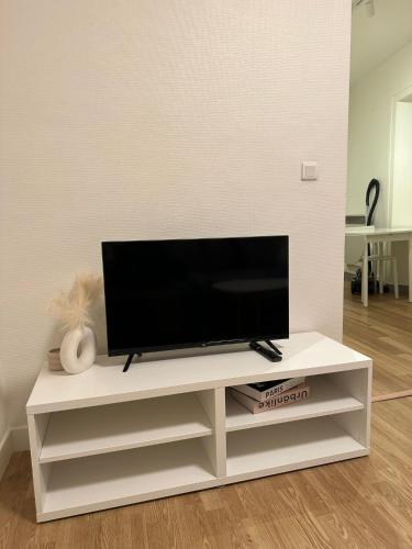 a white entertainment center with a flat screen tv on it at Lumineux et agréable in Asnières-sur-Seine