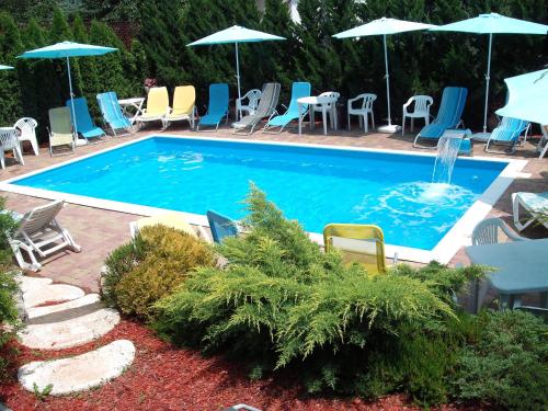 a swimming pool with chairs and a fountain at Apart Hévízi Ház in Hévíz
