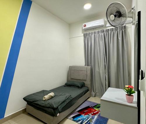a small room with a bed and a fan at Bayu Temiang Homestay in Seremban
