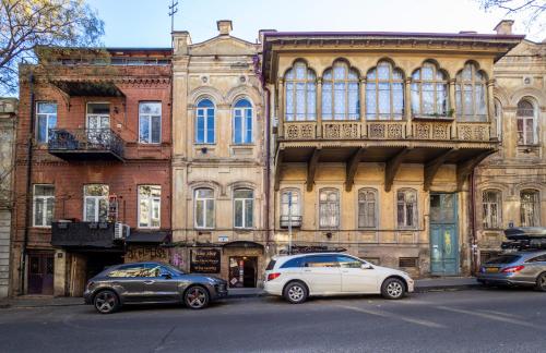 two cars parked in front of an old building at Heart of Tbilisi in Tbilisi City