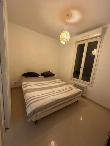 un lit dans une chambre avec une fenêtre dans l'établissement Appartement cozy 2 pièce, à Neuilly-Plaisance