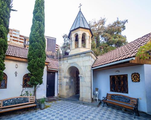 a church with a clock tower and a bench at Heart of Tbilisi in Tbilisi City