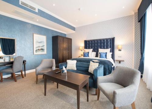 um quarto de hotel com uma cama, uma mesa e cadeiras em Hythe Imperial Hotel, Spa & Golf em Hythe