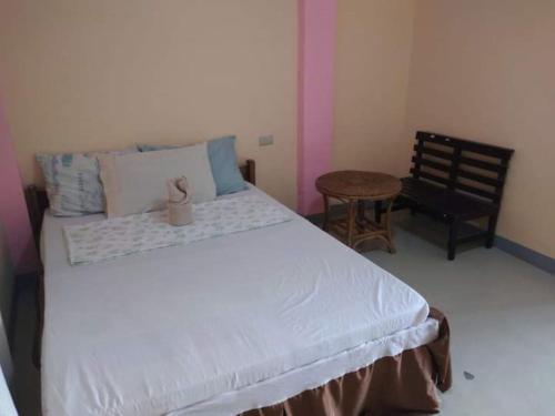 a bedroom with a large bed and a chair at Basio's Place Tourist Inn by RedDoorz in San Vicente