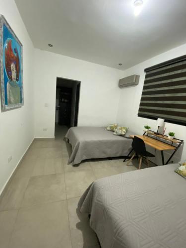 a bedroom with two beds and a desk in it at SweetHome in Monterrey