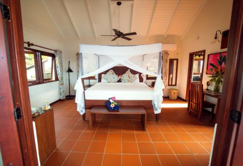 a bedroom with a bed with a white canopy at Ti Kaye Resort & Spa in Anse La Raye