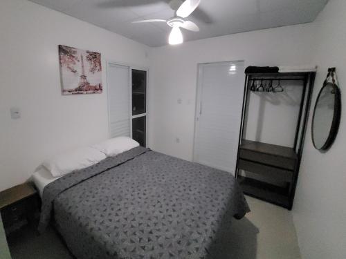 Un dormitorio con una cama y un ventilador de techo. en Stúdio Aconchegante, en Santa Maria