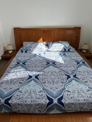 La caraïbe dans la station balnéaire في سانت فرانسوا: سرير عليه لحاف ازرق وابيض