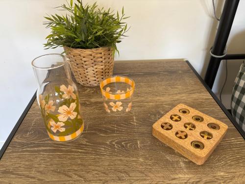 a table with a plant and two vases on it at Caba Beach Cabin in Cabarita Beach
