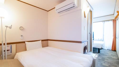 a bedroom with two beds and a window at Toyoko Inn Hokkaido Sapporo-eki Nishi-guchi Hokudai Mae in Sapporo