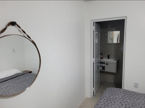 un espejo colgado en una pared junto a un dormitorio en Stúdio Aconchegante, en Santa Maria
