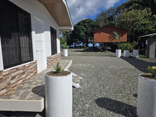 a house with three potted plants in front of it at Casa Tucan 2bdr beach house AC BBQ Playa Blanca in Puerto Jiménez