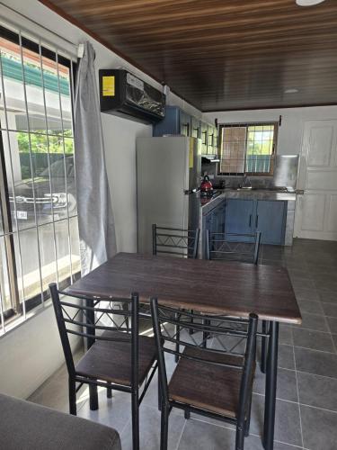 a kitchen with a table and chairs and a refrigerator at Casa Tucan 2bdr beach house AC BBQ Playa Blanca in Puerto Jiménez