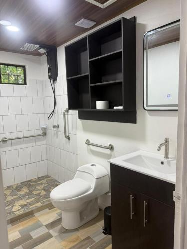 a bathroom with a toilet and a sink at Casa Tucan 2bdr beach house AC BBQ Playa Blanca in Puerto Jiménez