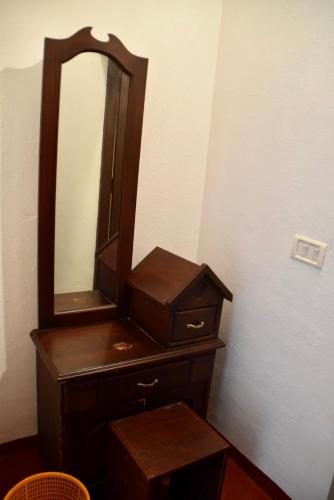a wooden dresser with a mirror on top of it at Marari Beach Villas in Mararikulam