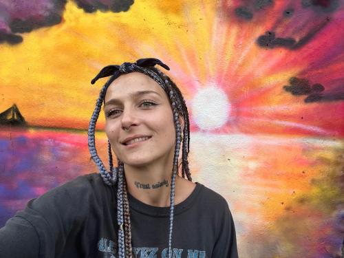 a woman with dread locks in front of a painting at Wonderland Master Bedroom in Petit-Bourg