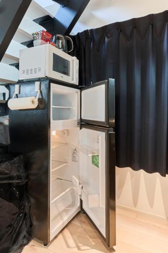 a refrigerator with a microwave on top of it at New東京で富士山が見えるPentohouse ZEN 奥沢駅1分自由ヶ丘徒歩6分渋谷電車15分 in Tokyo
