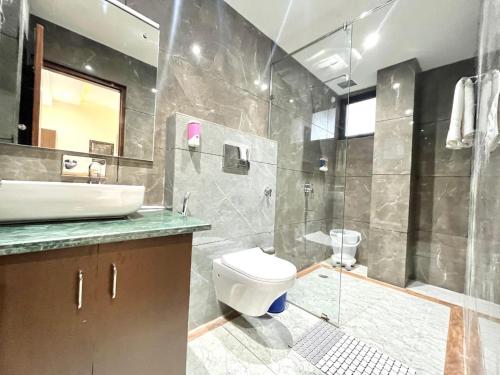a bathroom with a toilet and a sink and a shower at Kasauli Green View With Pool by Kasauli Vista in Kasauli