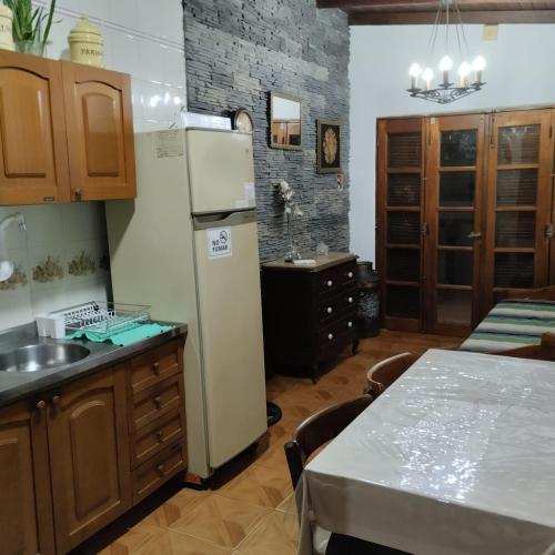 a kitchen with a white refrigerator and a table at Alojamiento Temporario San José in Paso de los Libres