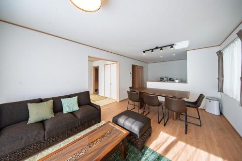 a living room with a couch and a table at Inamine K in Nago