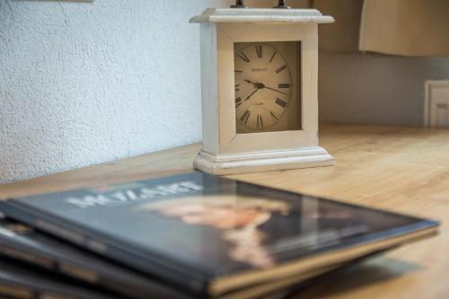 a clock sitting on a table next to a laptop at Appartements Lilly Rose in Zell am Ziller