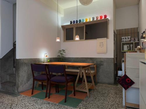 una pequeña cocina con mesa de madera y sillas en 可以住Canlive中西區海安路包棟民宿-一日只接待一組, en Tainan