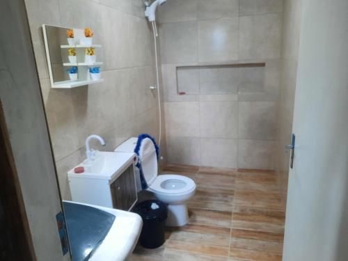 a small bathroom with a toilet and a sink at Servidão 1619 in Palhoça