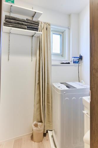 a laundry room with a refrigerator and a window at New東京で富士山が見えるPentohouse ZEN 奥沢駅1分自由ヶ丘徒歩6分渋谷電車15分 in Tokyo