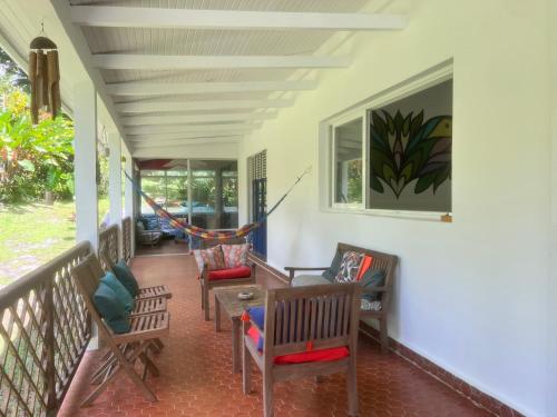 a porch with chairs and a hammock on it at Wonderland Master Bedroom in Petit-Bourg