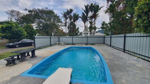 ein Schwimmbecken mit einer Bank und einem Zaun in der Unterkunft Lunar Villa A'Famosa Resort by Holiday Pool Villa in Kampong Ulu Pegoh