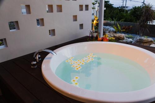 a bathroom with a tub filled with water at ヴィラ Cy MOTOBU 沖縄本部町 一棟貸し in Motobu