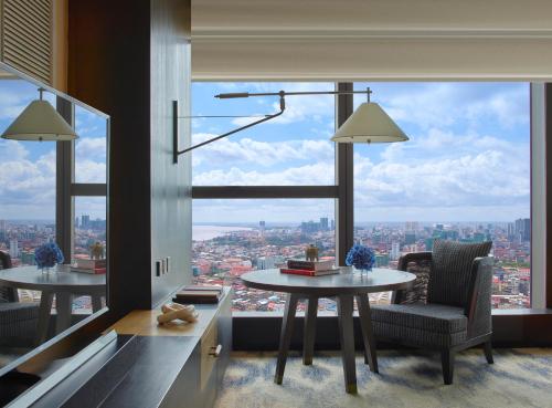 a room with a table and a large window at Rosewood Phnom Penh in Phnom Penh