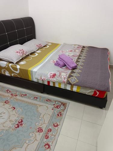 a bed with purple pillows on it in a room at Auni Homestay in Raub