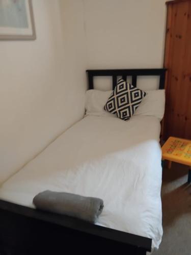 a bed with white sheets and a pillow on it at Ensuite Double Room, by Swansea University, Sketty, R2 in Swansea