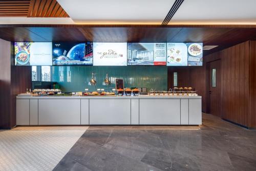a restaurant with a counter with food on it at Hilton Garden Inn Datong Pingcheng in Datong