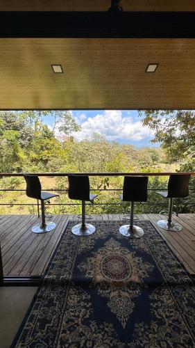 a balcony with chairs and a large window with a view at Modern Loft inside a beautiful farm in General Viejo