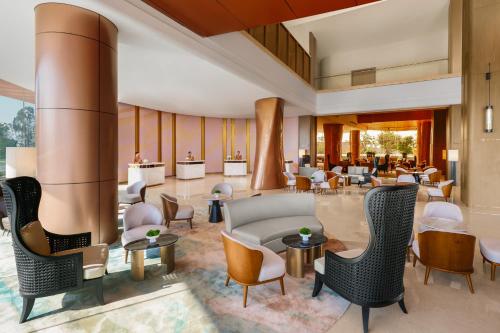 a lobby of a hotel with chairs and tables at Amari Vientiane in Vientiane