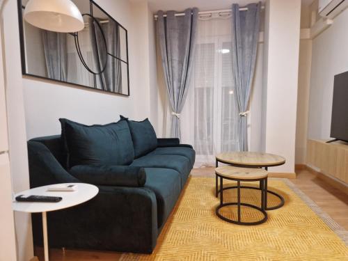 a living room with a blue couch and two tables at Visita Zaragoza in Zaragoza