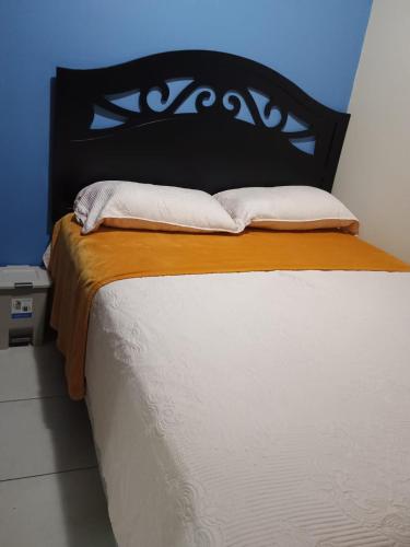 a bedroom with a bed with a black headboard at Tu casa fuera de casa in San Pedro Sula