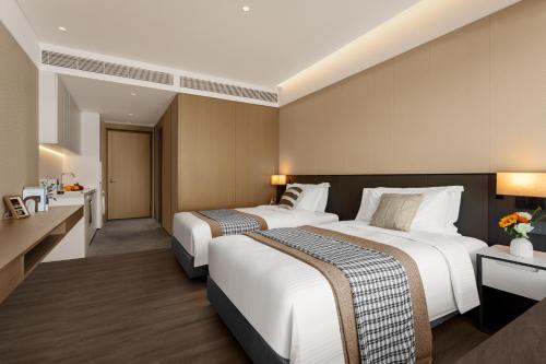 a hotel room with two beds and a kitchen at Ascott Fengyishan Shenzhen in Shenzhen