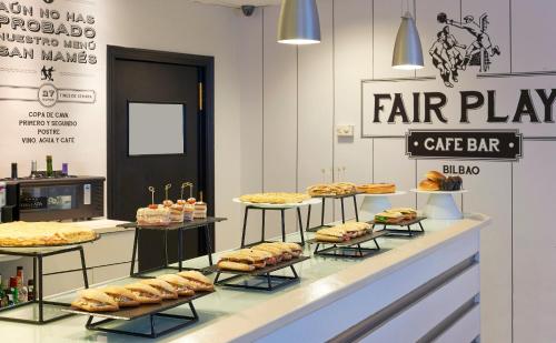 a bakery with various sandwiches and pastries on display at Abba Euskalduna Hotel in Bilbao