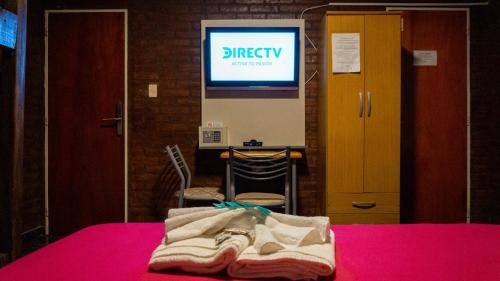 een kamer met een bed, een tv en een tafel bij Nuevo Hotel Carmel in Villa Parque Siquiman