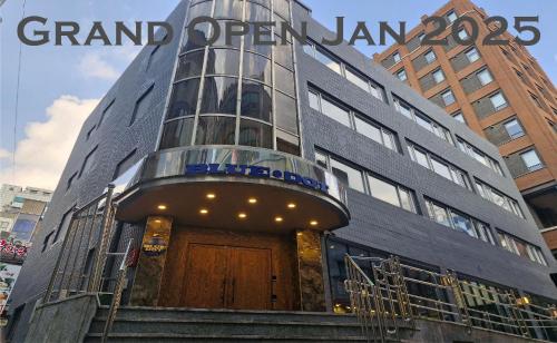 a building with a sign that reads grand open jam at Bluedot Poshtel in Seoul