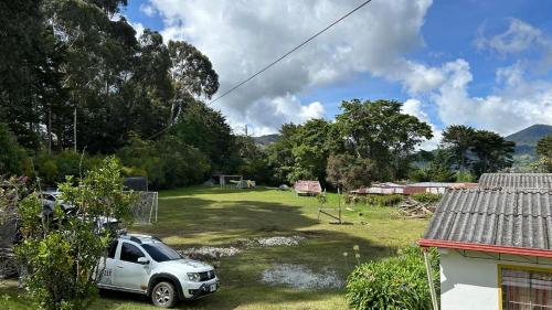 a car parked in a yard next to a house at CorpoAgro HJC in Sonsón