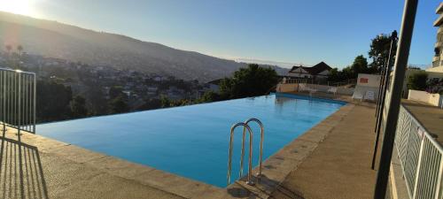 a large swimming pool with a view of a city at Ocean View & Pool Family Apartment 4P in Valparaíso