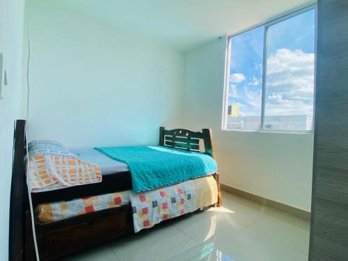 une chambre avec un lit et une grande fenêtre dans l'établissement Apartamento en Ricaurte - Reserva de Peñalisa, à Ricaurte