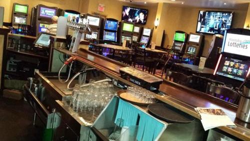 a bar with many televisions in a casino at Park West Inn in Winnipeg