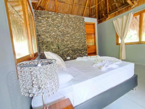 a white bed in a room with a window at Colibri Parque Tayrona Dentro del Parque Nacional Tayrona in El Zaino